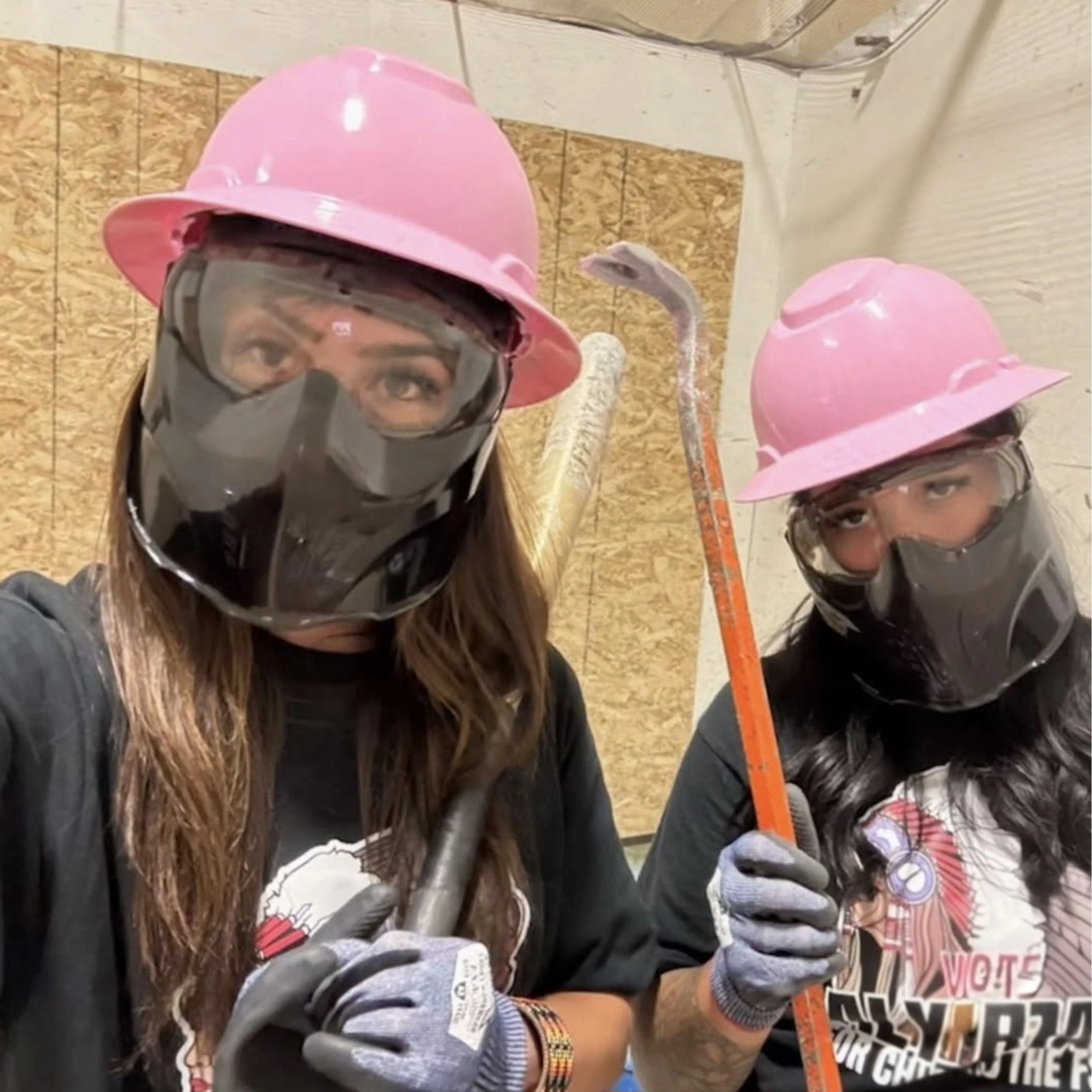 Two women wearing protective gear in a smash room Two women wearing protective gear in a smash room